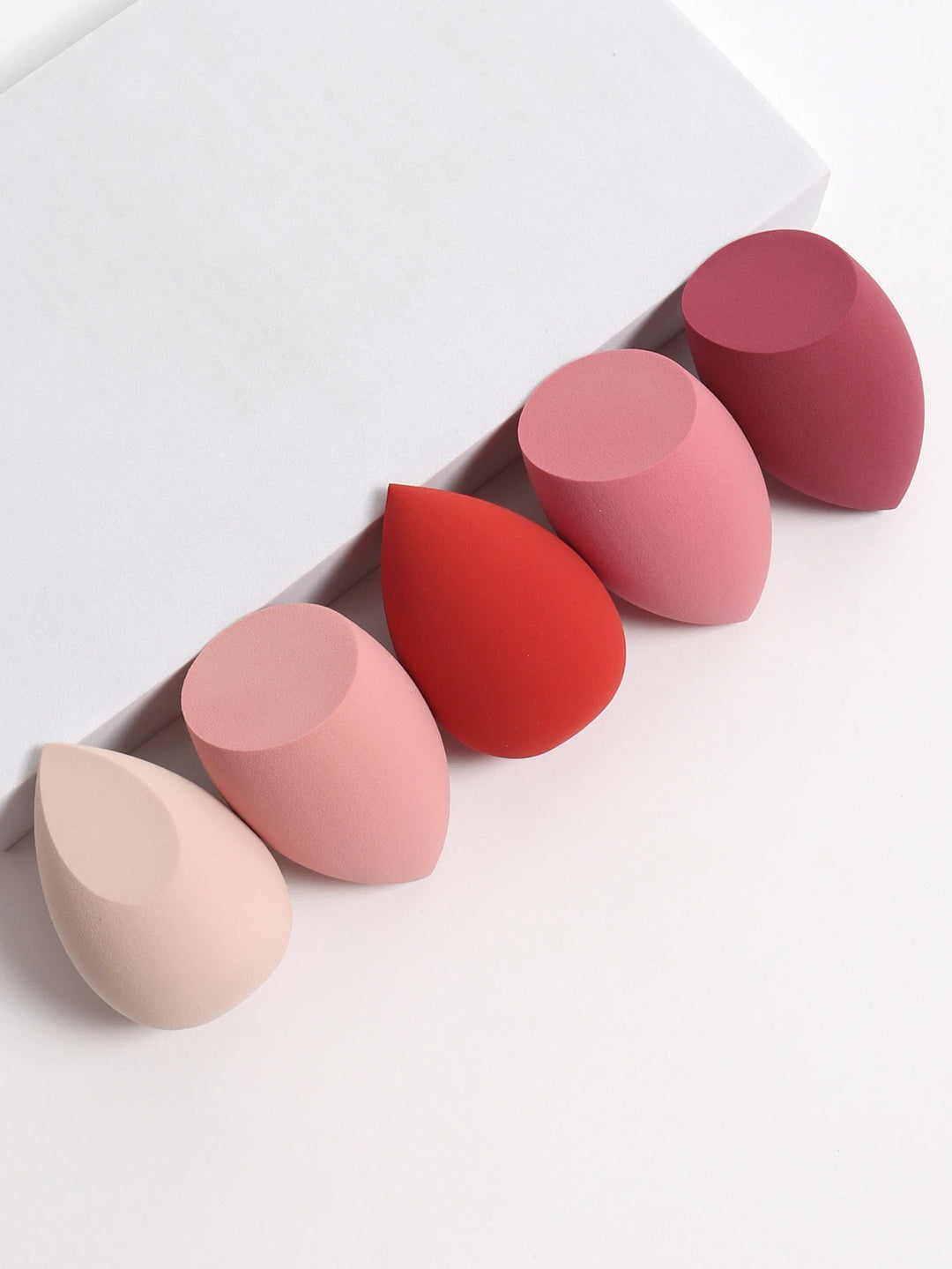 Bags of Beauty Eggs Makeup - Ensemble d'éponges de maquillage en différentes teintes sur fond blanc.
