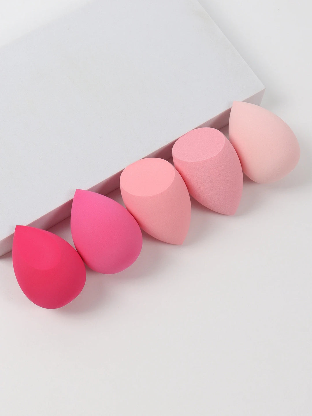 Bags of Beauty Eggs Makeup - Ensemble d'éponges de maquillage en différentes teintes sur fond blanc.